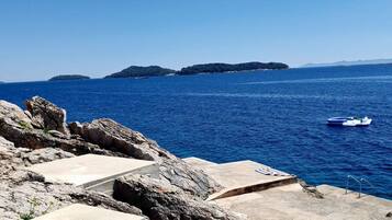 A coastal view with rocky terrain and a clear blue sea.