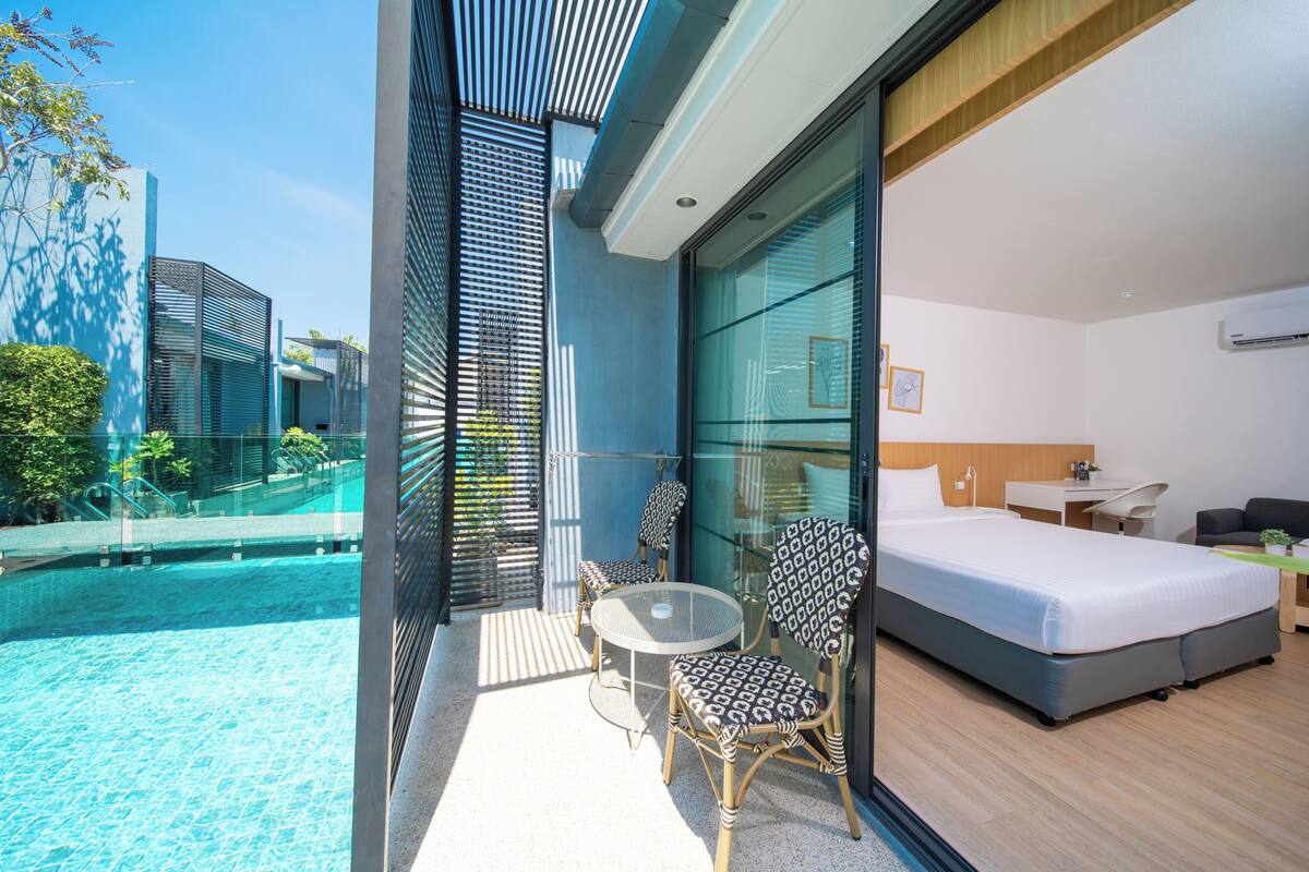 Una habitación de hotel moderna con balcón, cama, escritorio y silla.
