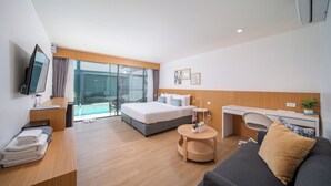 Ein modernes Hotelzimmer mit Bett, Schreibtisch und Sitzgelegenheit.