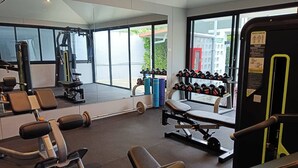 Ein Fitnessstudio mit Krafttrainingsgeräten, Trainingsmaschinen und Kurzhanteln.