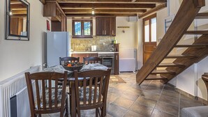Une cuisine avec des meubles en bois, un réfrigérateur et un coin repas comprenant des chaises et une table.
