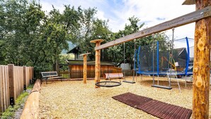 Ein Spielplatz mit Schaukeln, einer Wippe und einer Kletterkonstruktion.