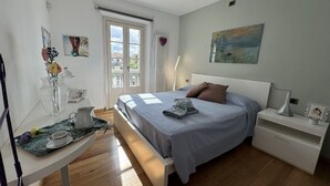A bedroom with a bed, bedside table, and a window with blinds. - Charming Tuscan Home with Pool near Lucca (Lucca)