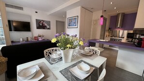 A modern living room with a dining area, a kitchen, and a TV mounted on the wall. - Charming Tuscan Home with Pool near Lucca (Lucca)