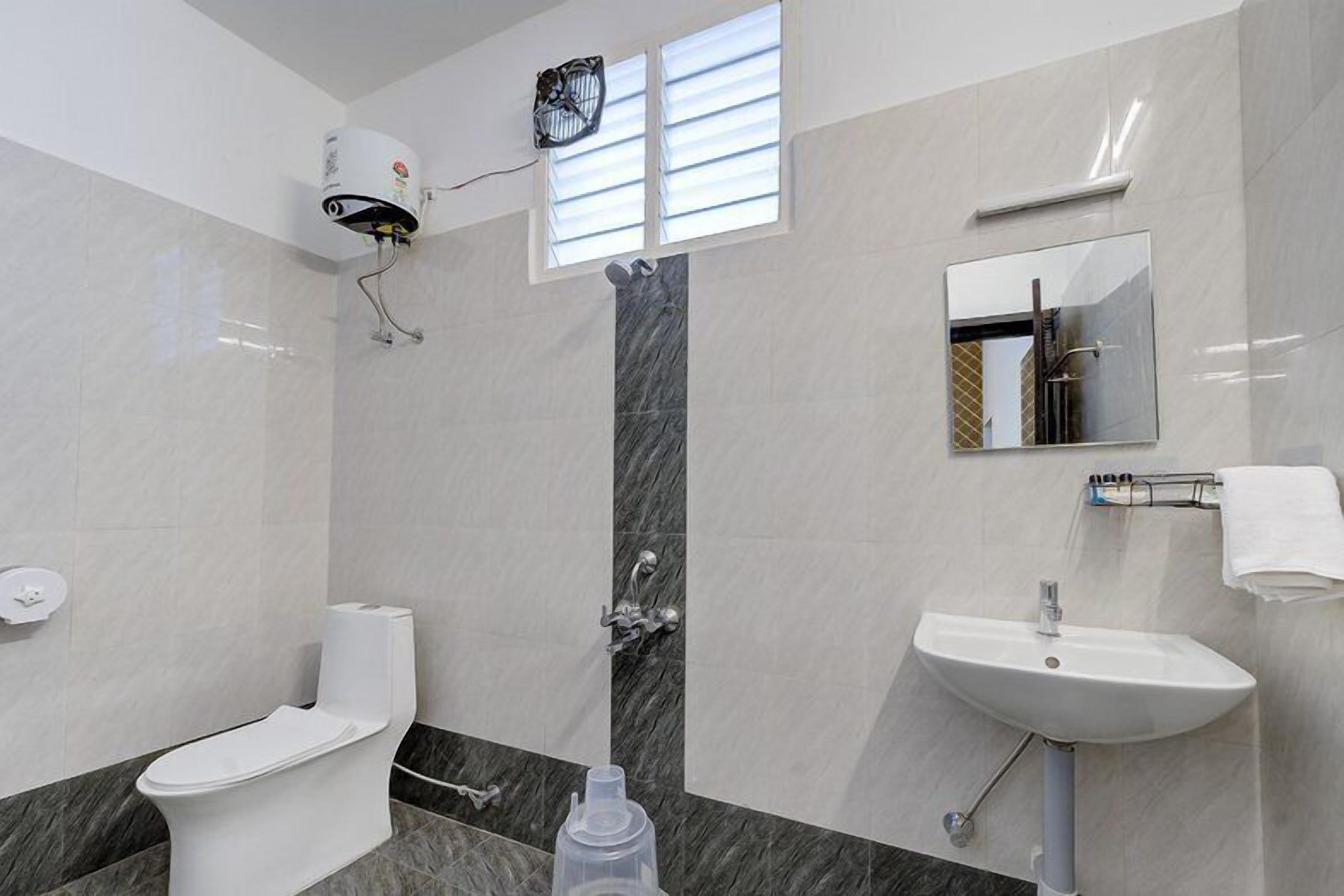 A modern bathroom with a toilet, sink, and mirror.