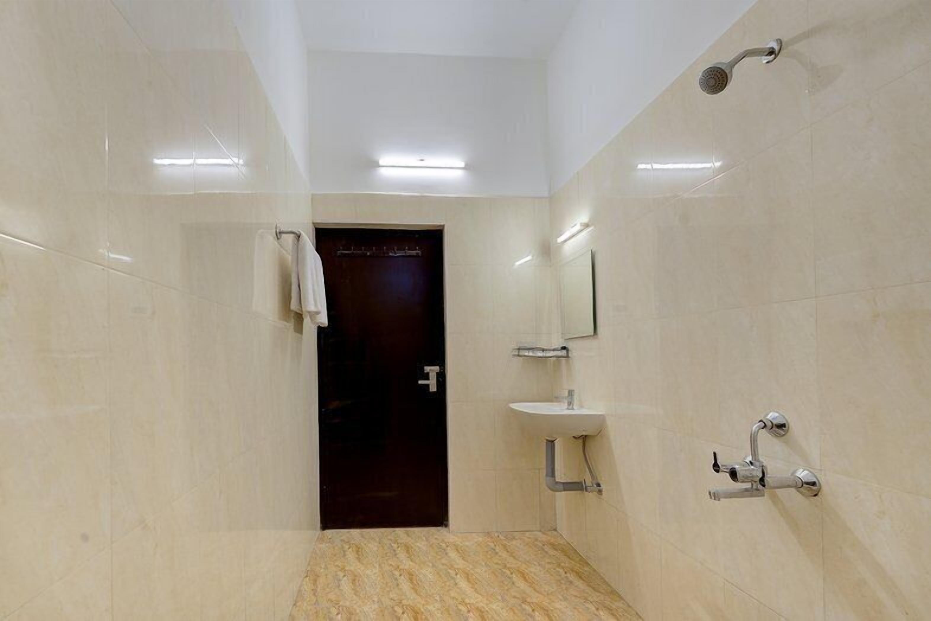 A modern bathroom with a marble floor, a sink, a mirror, and a shower.
