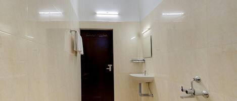 A modern bathroom with a marble floor, a sink, a mirror, and a shower.