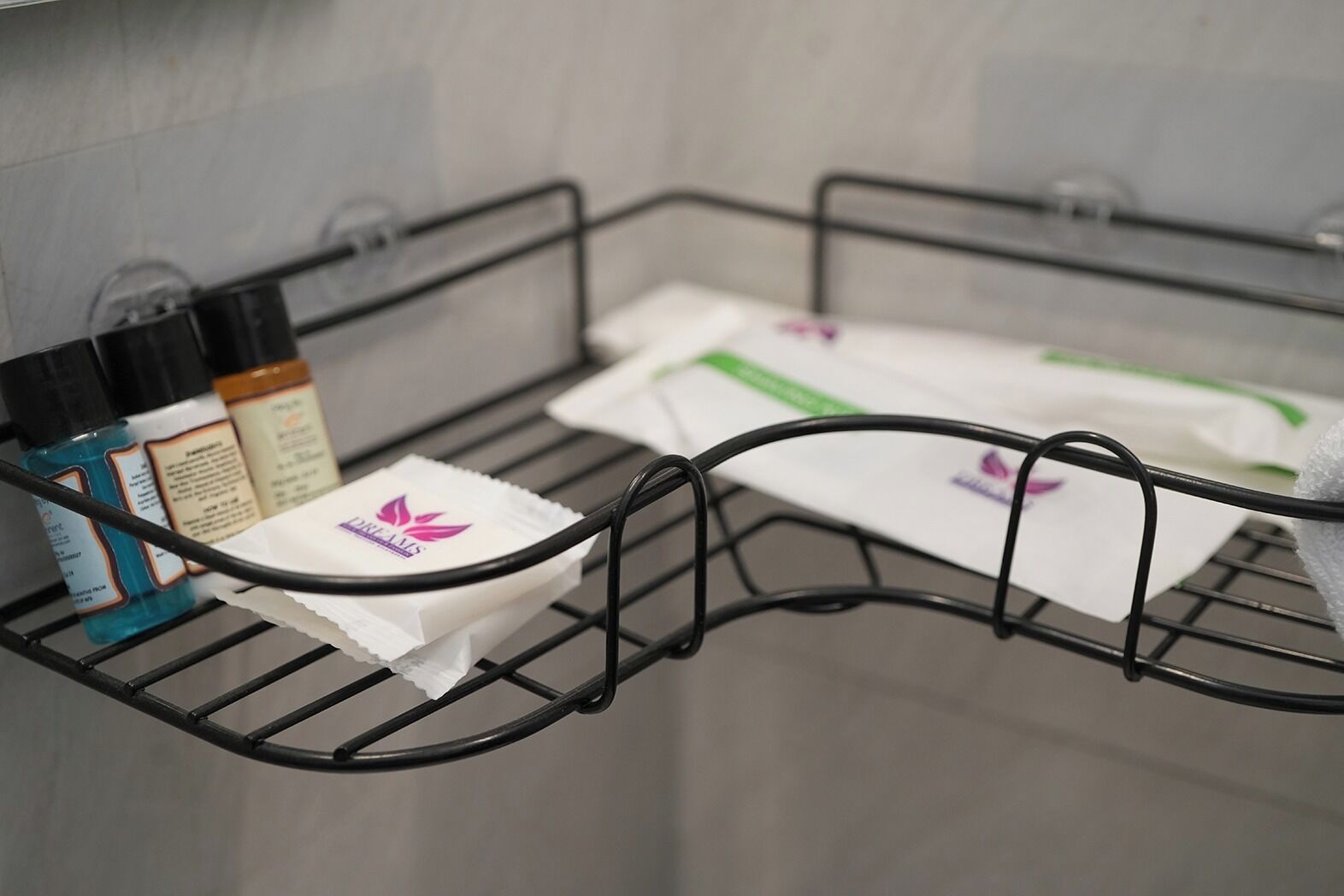 A metal rack with toiletries and a white towel in a bathroom.