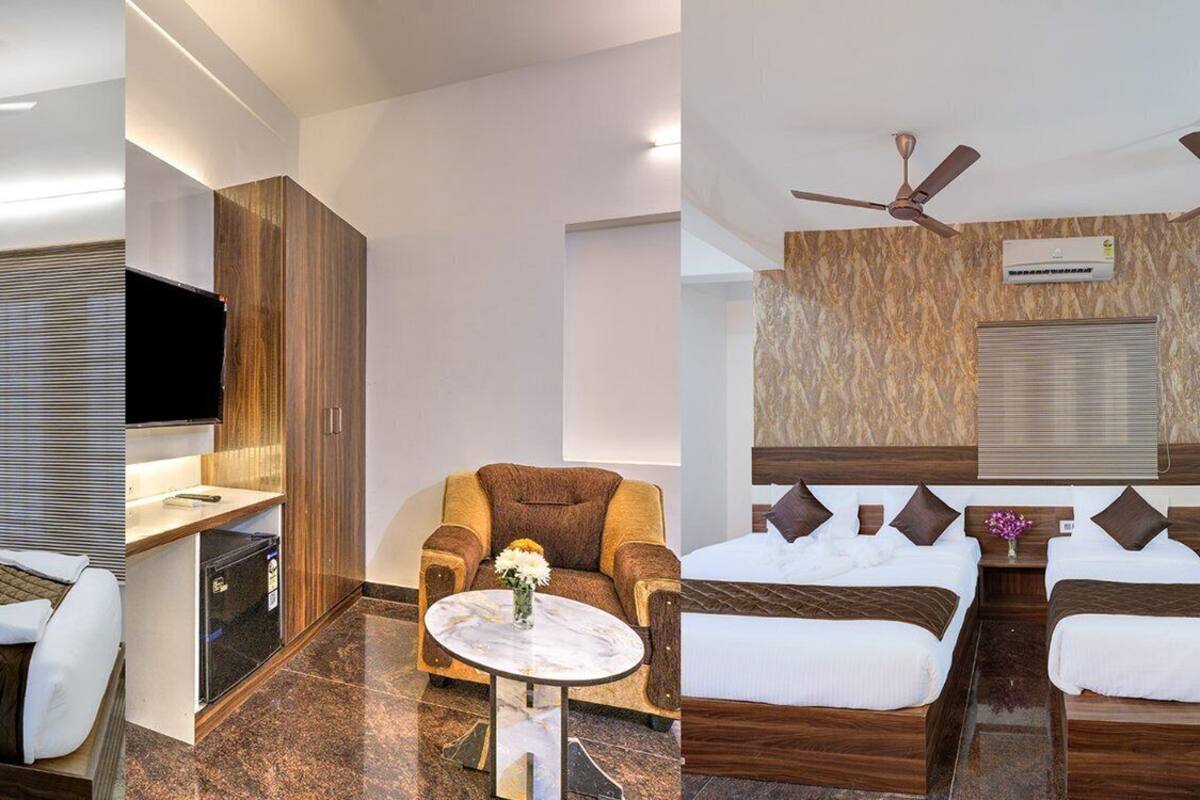 Quarto de hotel com cama, escrivaninha, cadeira e ventoinha no teto.