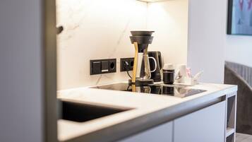 Una cocina moderna con cafetera, lavaplatos y encimera.