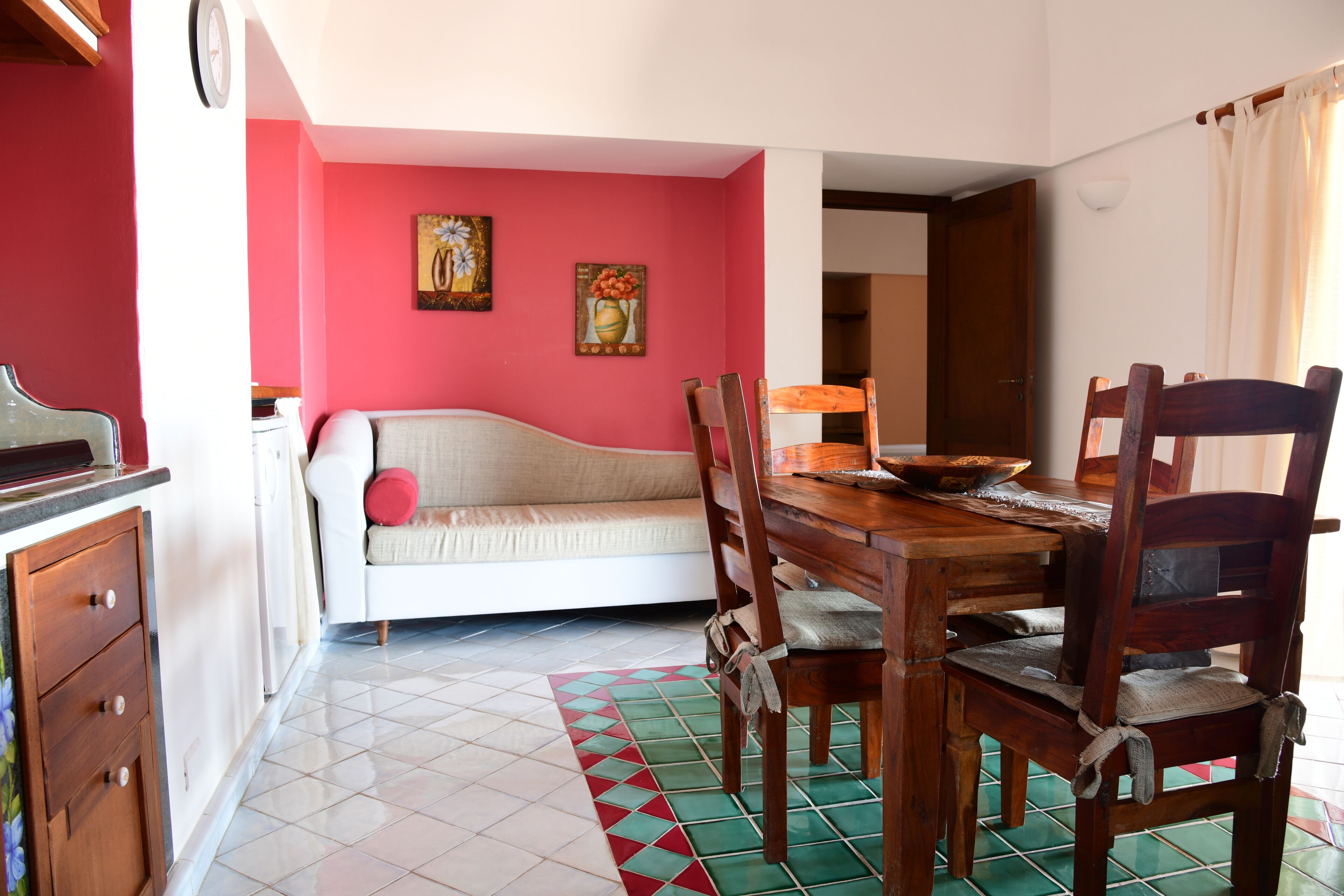 A dining area with a wooden table, chairs, and a sofa.