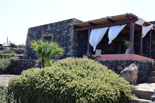 A stone building with a covered porch and a red roof.