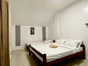 A room with two single beds, a radiator, a wall-mounted picture, and a curtain. - Trail Inn - Puerto Princesa City (Puerto Princesa)