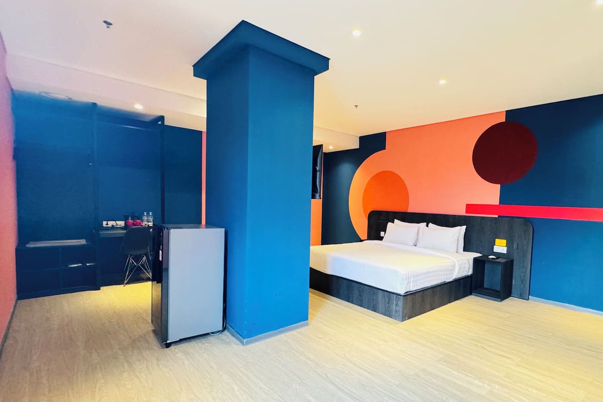 Un dormitorio moderno con cama, mesita de noche y escritorio con silla.