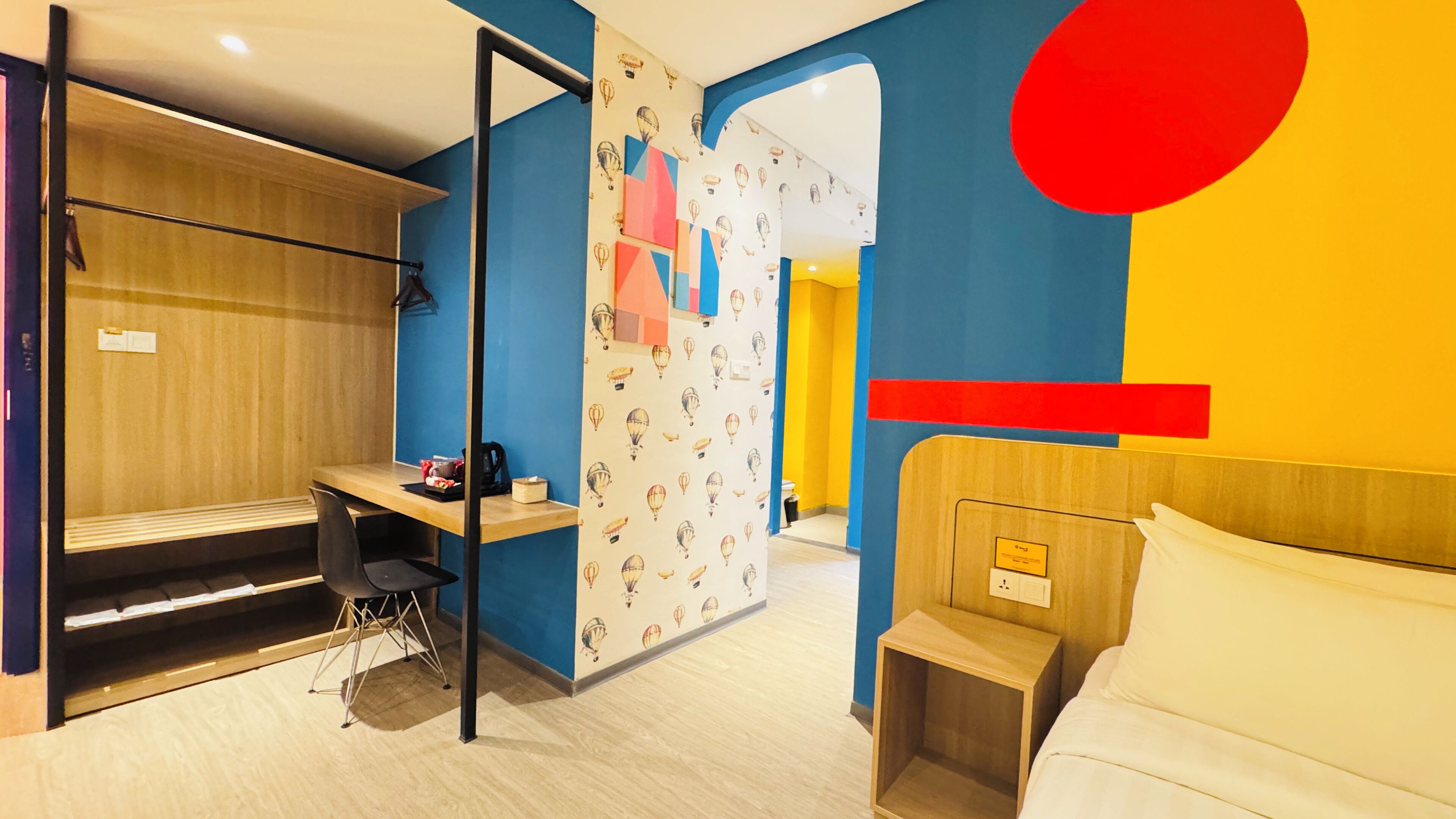 A modern hotel room with a bunk bed, a desk, and a small bedside table.
