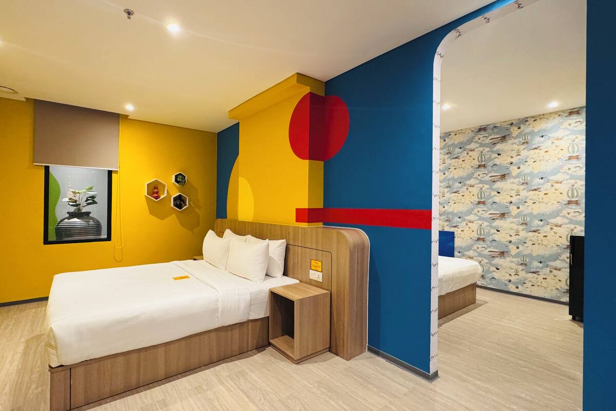 Una habitación de hotel moderna con una cama grande, una mesita de noche y un espejo.