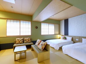 A hotel room with a sofa, two beds, a small table, and large windows. - Onyado Nono Matsue Hot Spring (Matsue)