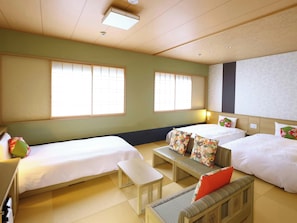 A hotel room with two beds, a small table, and a bench. - Onyado Nono Matsue Hot Spring (Matsue)