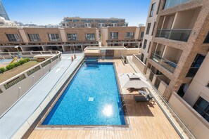 A heated pool - Chic 1-BR w/ Pool & Gym Access (Dubai)