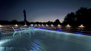 A deck with outdoor furniture and a patterned rug. - Charming Upstairs 2-bedroom townhome W/ side entrance & Balcony in Kyle AC, WiFi (Kyle)