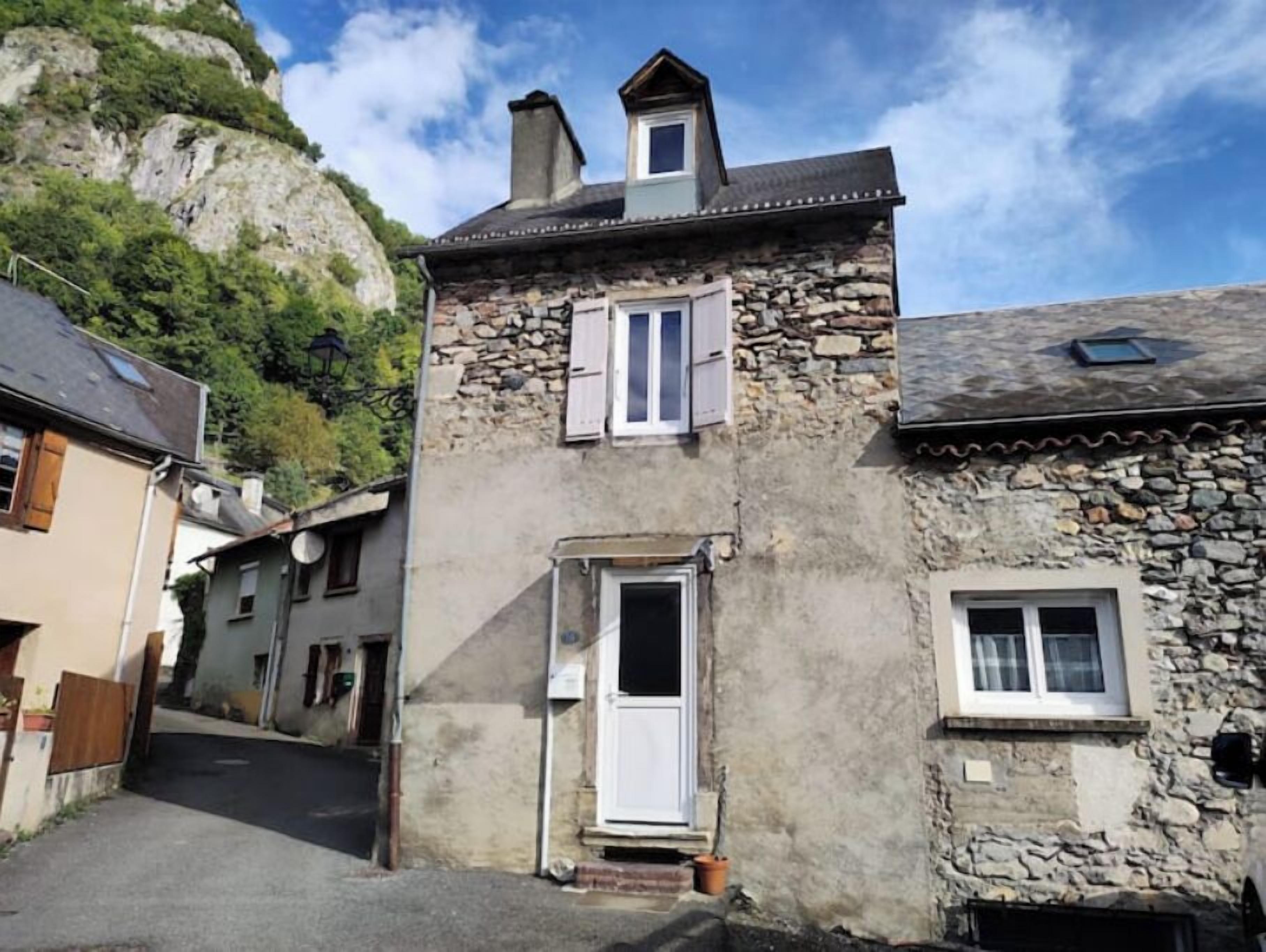 A narrow street with stone buildings, a small door, and a window.