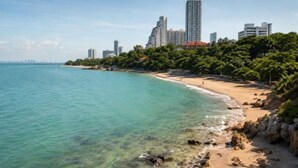 A coastal cityscape with a beach, clear water, and high-rise buildings. - Friends Station Hostel & Cafe (Pattaya)