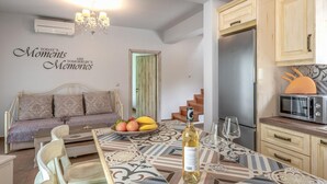 Une cuisine moderne avec un coin repas, un canapé et un mur orné d’une citation inspirante.