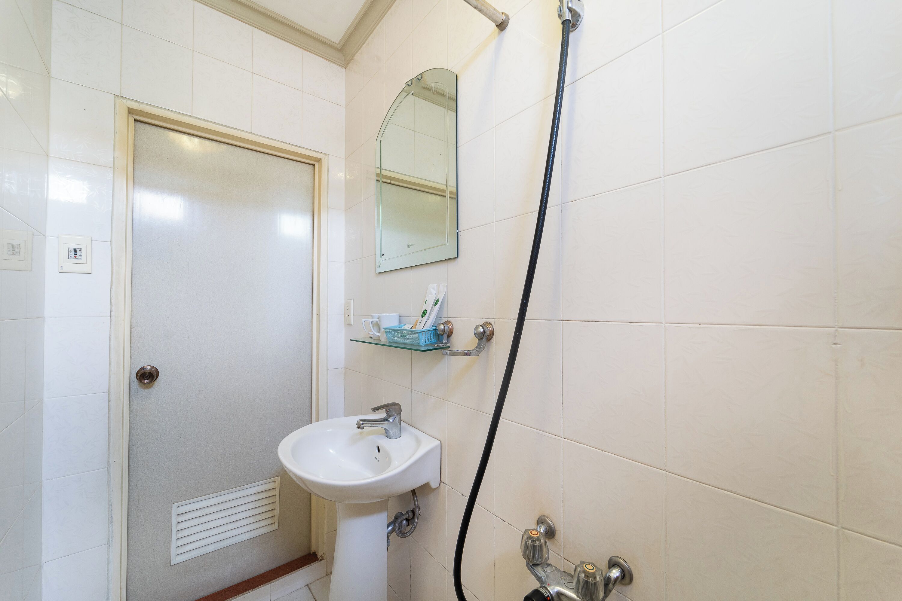 A bathroom with a white sink, a mirror, and a shower.