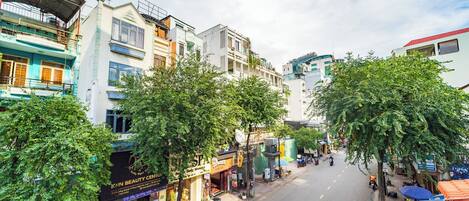 A street view with buildings, trees, and a clear sky.