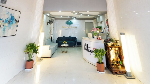 Un hall d'hôtel doté d'un lustre moderne, d'un comptoir d'accueil et d'un espace salon.