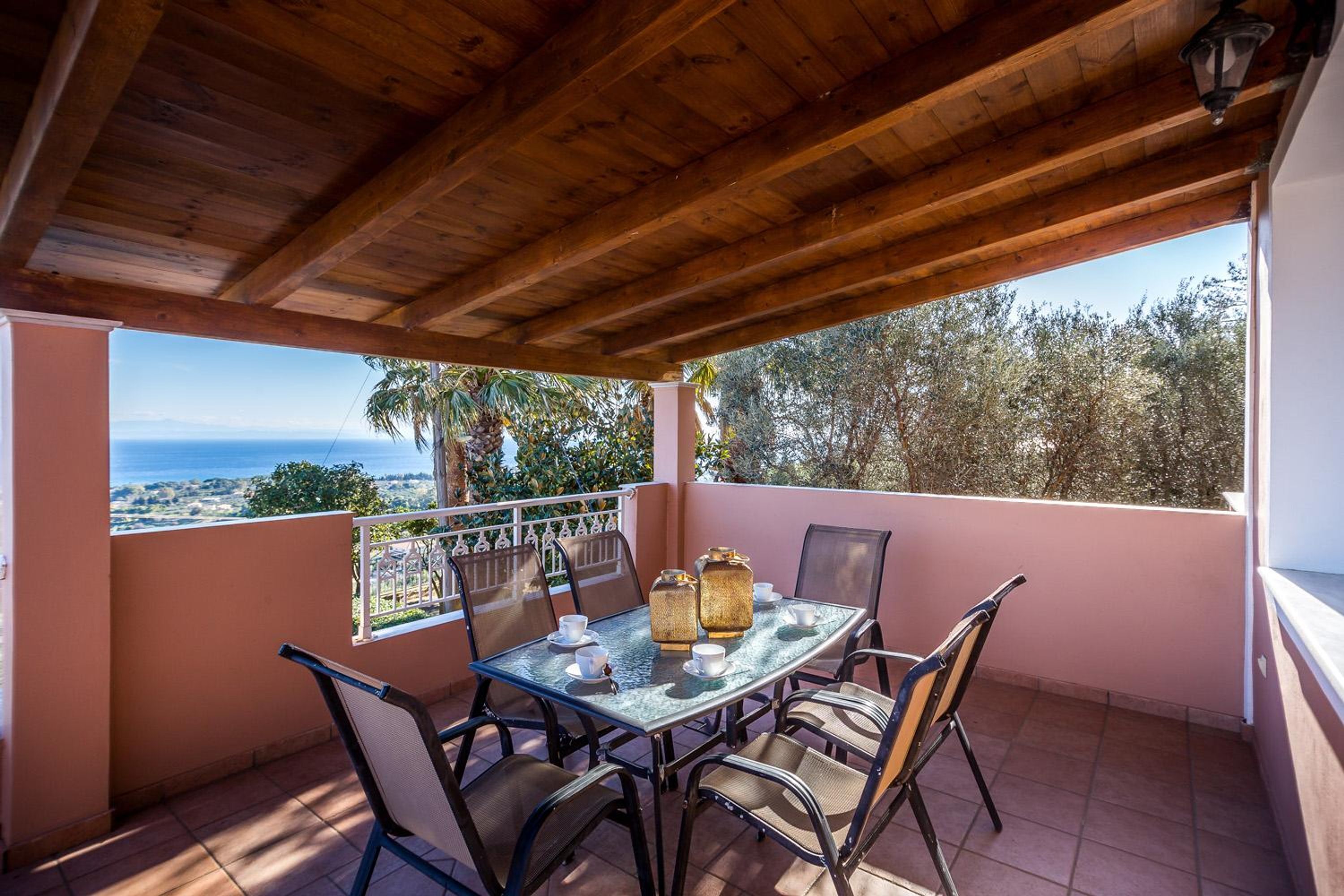 Une terrasse extérieure couverte, dotée d’une table et de chaises, qui offre une vue panoramique.