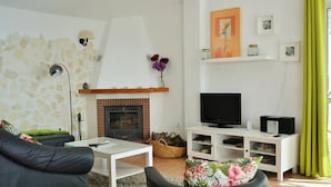 A living room with a fireplace, television, and a white entertainment unit. - Villa Buenavista in C Mpeta (Torrox)