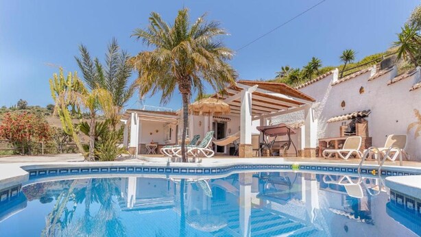 A pool with lounge chairs and a pergola, surrounded by palm trees and a white building. - Villa Buenavista in C Mpeta (Torrox)