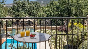 A terrace with a table, chairs, and a view of the sea. - Villa Chloe in Rethymno (Rethymno)