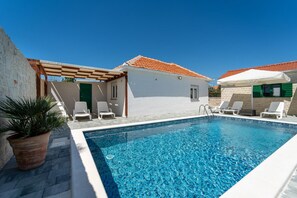 A swimming pool with a clear blue water, surrounded by white walls and a tiled roof. - Villa Iva in Donje Ra Tane (Sveti Filip i Jakov)