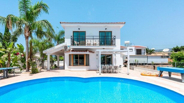 Una casa de dos pisos con una piscina delantera.