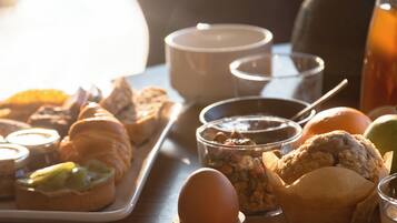 A breakfast table with pastries, a cup, and a teapot.