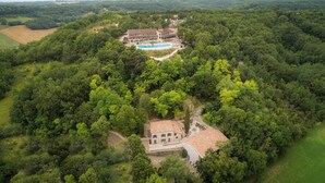 Vista aérea de una extensa propiedad con piscina, rodeada de bosque denso.