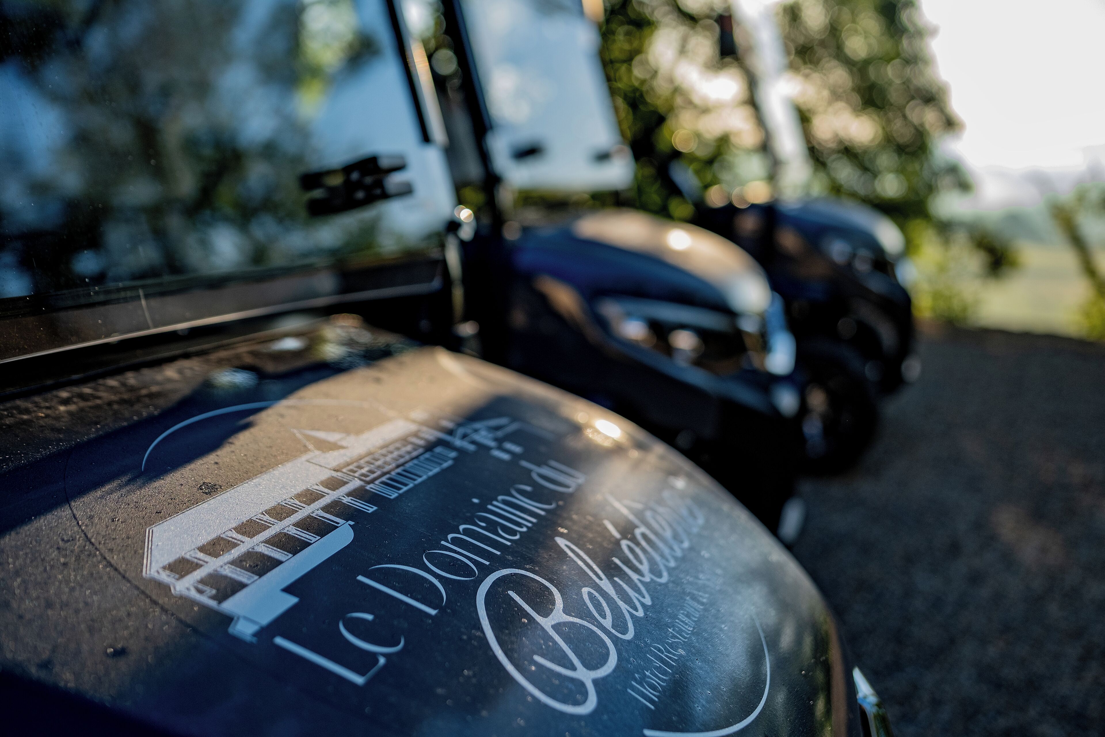 A vehicle with a logo and text indicating it is part of a tour or event.