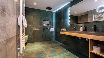 Een moderne badkamer met douche, toilet en wastafel.