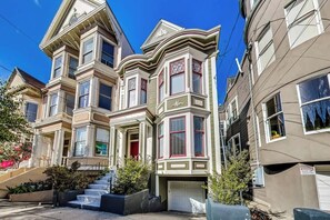 A Victorian-style building with bay windows, a front entrance, and a garage.