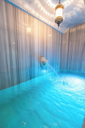 A room with a large water feature, a ceiling light, and a wall-mounted object. - Royal Capital Hotel Thermal & SPA (Bursa)