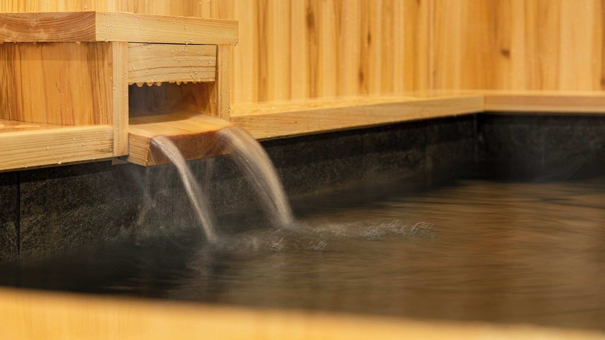 A wooden sauna with a visible water flow.