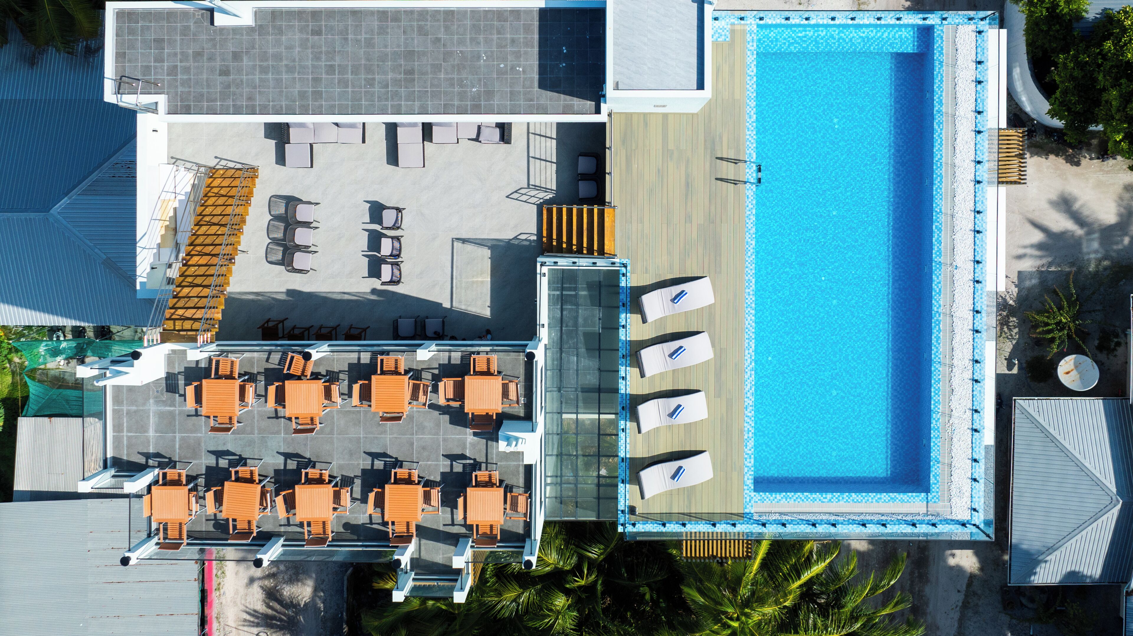 Vue aérienne d’un hôtel doté d’une piscine, d’un espace extérieur aménagé et d’une terrasse couverte.