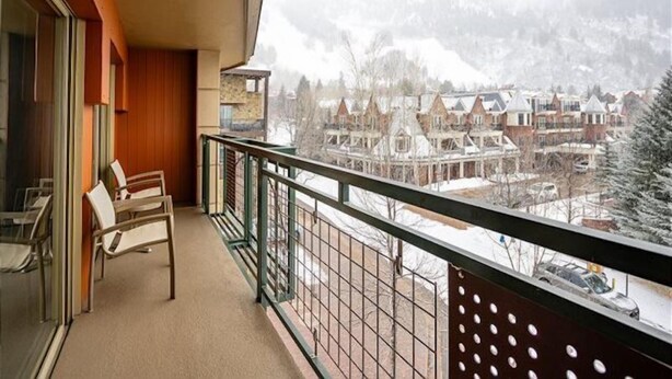 A balcony with a view of a snowy residential area and mountains. - 3 Bedroom Gold-rated Condo at the Base of Aspen Mountain (Aspen)