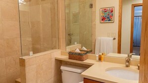 A bathroom with a glass-enclosed shower, a sink with a mirror, and a toilet. - 3 Bedroom Gold-rated Condo at the Base of Aspen Mountain (Aspen)