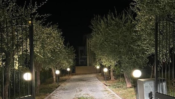 A pathway flanked by trees and illuminated by street lamps, leading to a building. - Apartment - Sleeps 4 - Pet Friendly (Monsummano Terme)