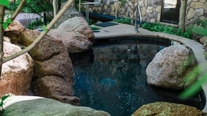 A pool surrounded by large rocks and a stone wall. - 3 Bedroom Condo at Historic Lift 1A in Downtown Aspen (Aspen)