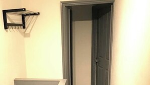 A hallway with a door and a black-framed window.