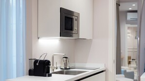A modern kitchen with a built-in microwave, a coffee machine, and a kettle. - SUITE CLARICE & LUCREZIA Le 5 Lampade Florence (Firenze)